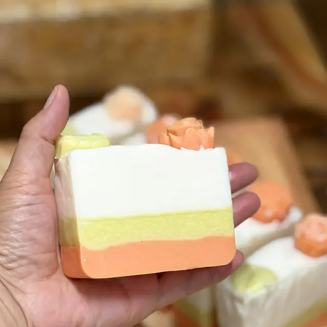 Barras em camadas creme, verde e laranja com flores e suculentas no topo, foto 2 de 4