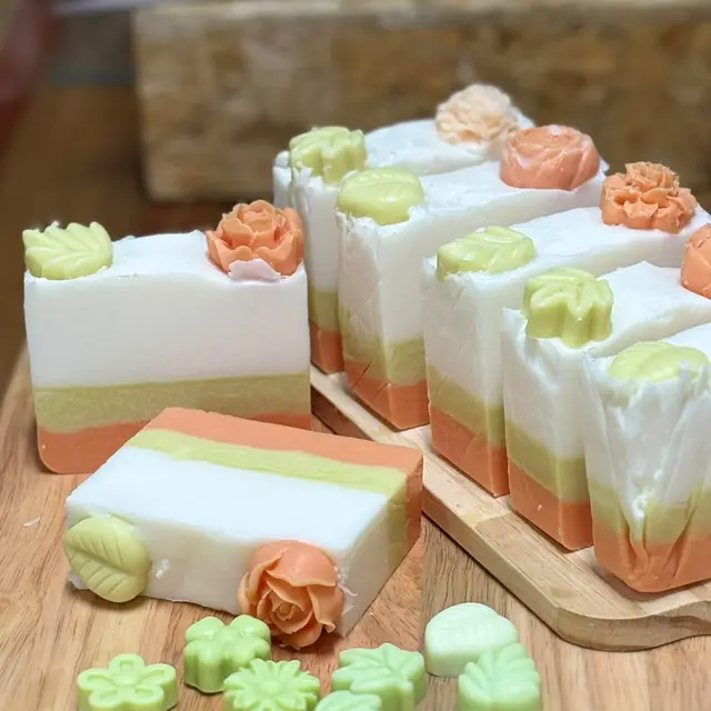 Barras em camadas creme, verde e laranja com flores e suculentas no topo, foto 3 de 4