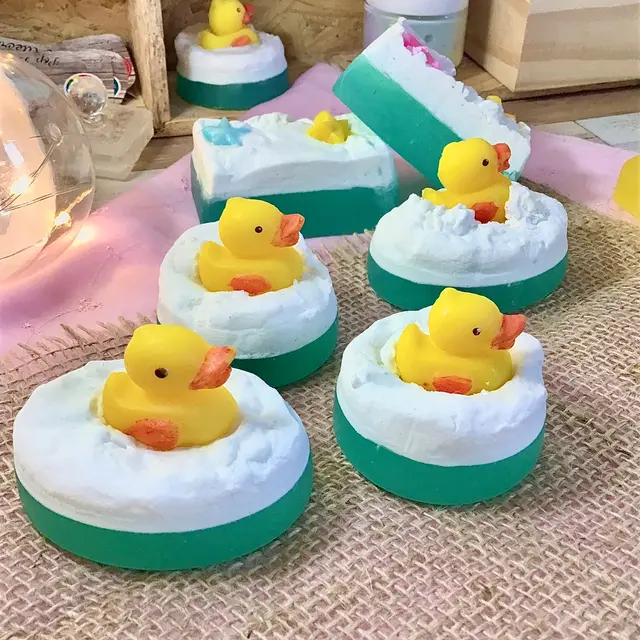 Sabonetes brancos e verdes com um patinho amarelo no topo